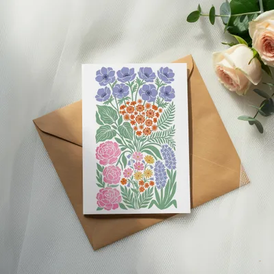 Floral greeting card with purple, pink, and orange flowers on a brown envelope.