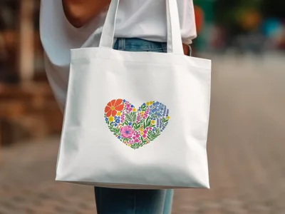 White tote bag with a colorful floral heart design.