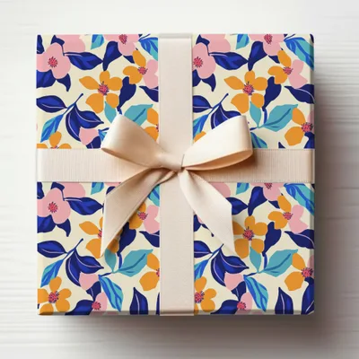 Gift-wrapped box with pink and blue floral pattern and cream ribbon.