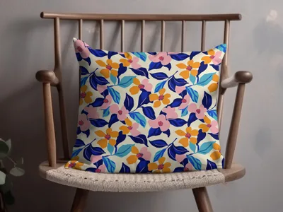 Cream pillow with a vibrant floral pattern in pink, orange, blue, and green.