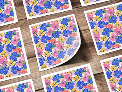 Floral pattern on cards with blue, pink, and yellow flowers on a wooden surface.