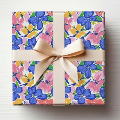 Gift-wrapped box with a pastel ribbon and a floral pattern of blue and pink flowers.