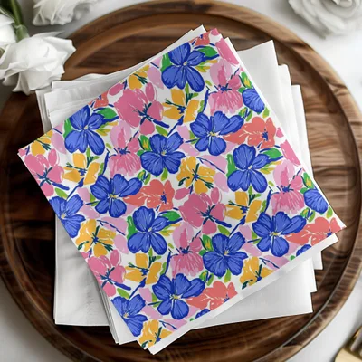 Colorful floral pattern napkins on a wooden tray with white napkins.