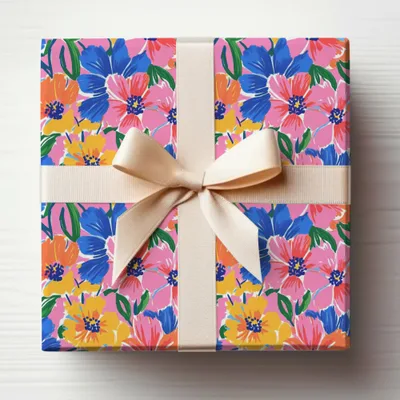 Gift-wrapped box with bold floral pattern and cream ribbon bow.