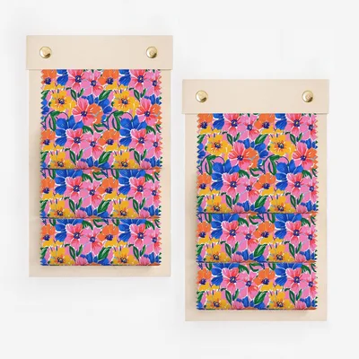 Two fabric swatches with colorful floral patterns in pink, blue, yellow, and green.