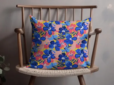 Blue and pink floral pattern on a yellow throw pillow on a wooden chair.