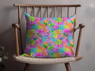 Throw pillow with a vibrant, abstract floral pattern in pink, blue, and orange.