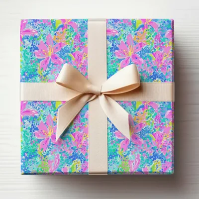 Gift-wrapped box with a floral pattern and a beige ribbon.