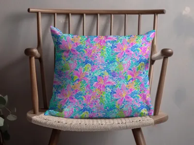 Pink and blue floral print pillow on a wooden chair.