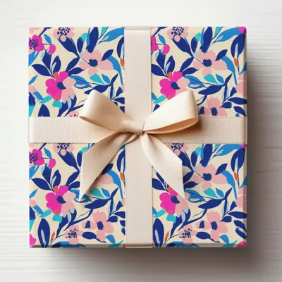 Gift-wrapped box with beige ribbon and floral pattern.