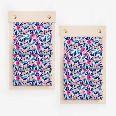 Floral fabric swatches on wooden hangers with brass fasteners.