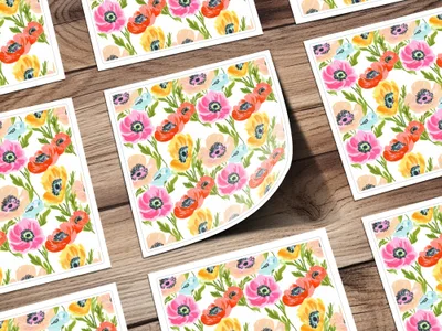 Floral pattern of poppies on cards arranged on a wooden surface.