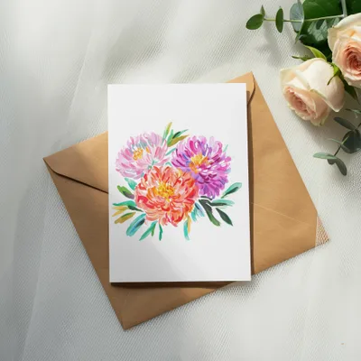 Watercolor floral illustration on a card atop a kraft envelope with roses.