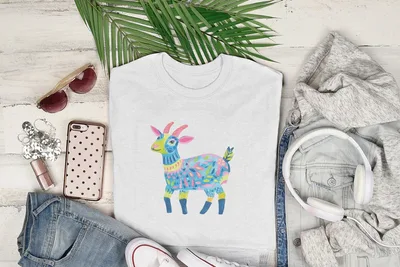 White t-shirt with colorful patterned goat illustration, styled with clothing and accessories.