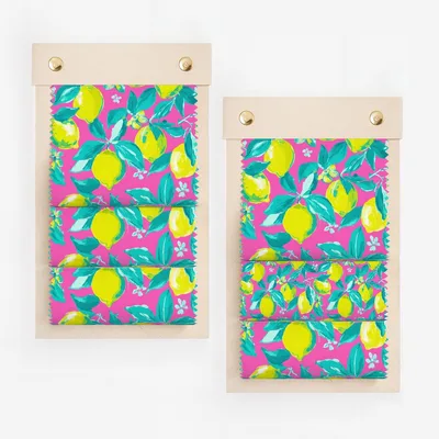 Two fabric swatches with a bright pink background and a repeating lemon and leaf pattern.