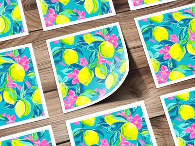 Colorful lemon and pink flower pattern on postcards scattered on a wooden surface.