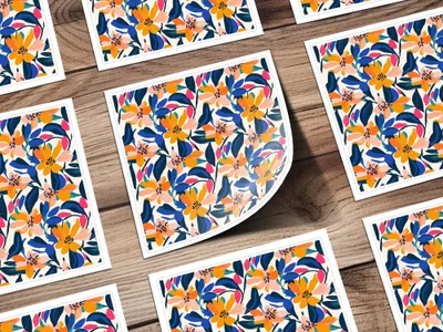 Pattern of colorful abstract flowers and leaves on white cards arranged on a wooden surface.