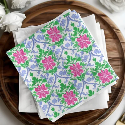 White napkins with a pink floral and blue vine pattern.