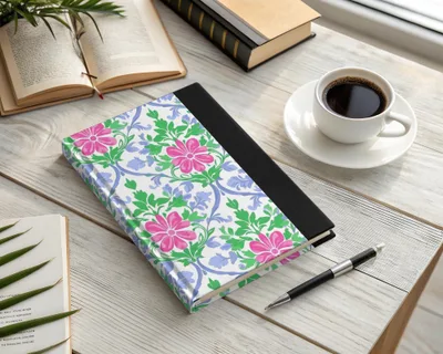 Notebook with pink and blue floral pattern, open book, and coffee.