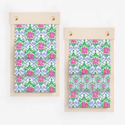Two fabric swatches with a repeating floral pattern of pink and blue flowers.