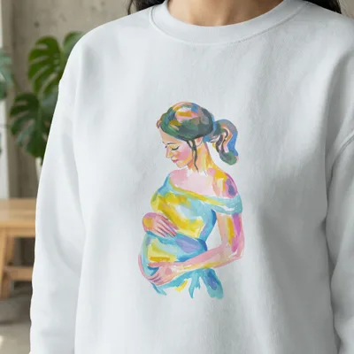 Watercolor painting of a pregnant woman holding her belly on a white sweatshirt.