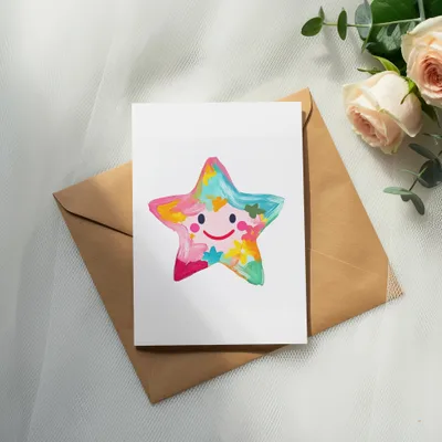 Colorful painted star card with smiling face on brown envelope.