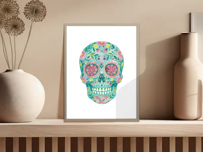 Colorful floral skull art in a frame on a shelf.