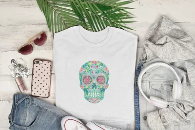 White t-shirt with colorful floral sugar skull design, flat lay.