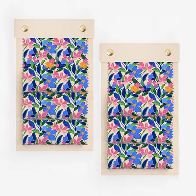 Swatches of fabric with a colorful floral pattern of pink, blue, and green.