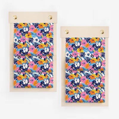Two fabric swatches with a vibrant floral pattern on a wooden board.