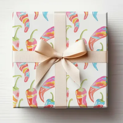 Gift-wrapped box with colorful chili peppers and a beige ribbon.