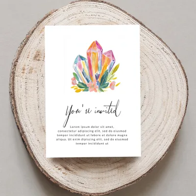 Invitation with watercolor crystals, flowers, and "You're invited" text.
