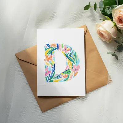 Card with a colorful floral letter "D" on a brown envelope.