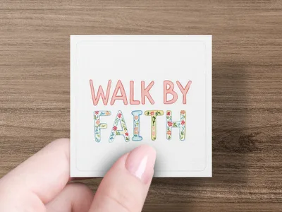 Square card with "WALK BY FAITH" in colorful letters, held by fingers.