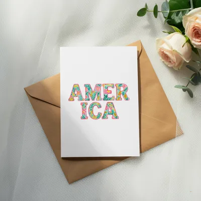 Card with "AMERICA" in floral lettering on an envelope.