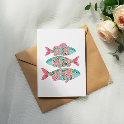 Watercolor card with three colorful fish and floral patterns on brown envelope.