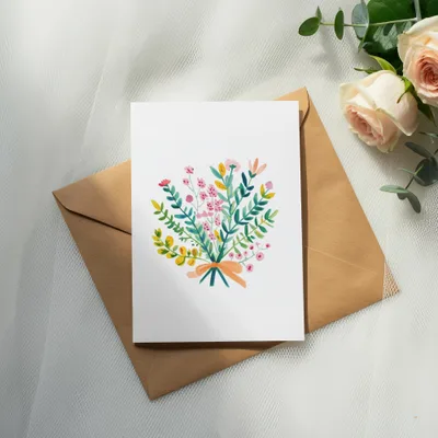 Watercolor bouquet illustration on white card with orange envelope and roses.