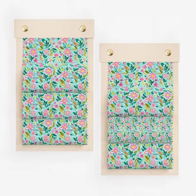 Two fabric swatch books with teal background floral pattern.
