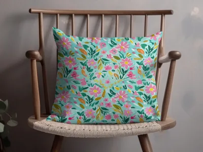 Teal throw pillow with pink and green floral watercolor pattern.