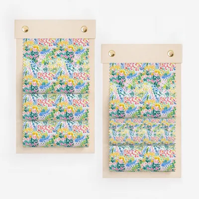Two fabric swatches displayed on wooden boards with floral patterns.