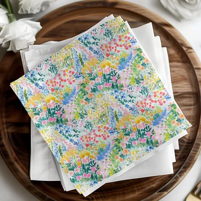 Watercolor floral print napkins stacked on a wooden tray.