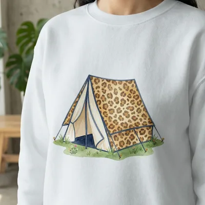 White sweatshirt featuring a watercolor leopard print tent in a grassy field.