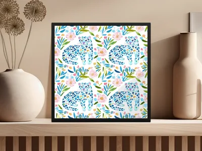 Framed artwork of repeating blue and white leopards among pink and green watercolor flowers.