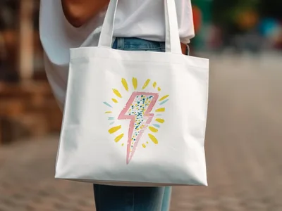 White canvas tote bag with a pink and yellow watercolor lightning bolt design.