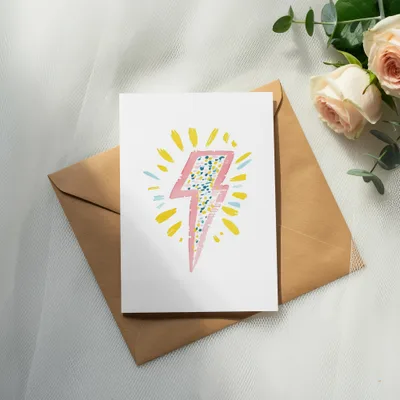 Card with pink and yellow lightning bolt illustration on brown envelope.