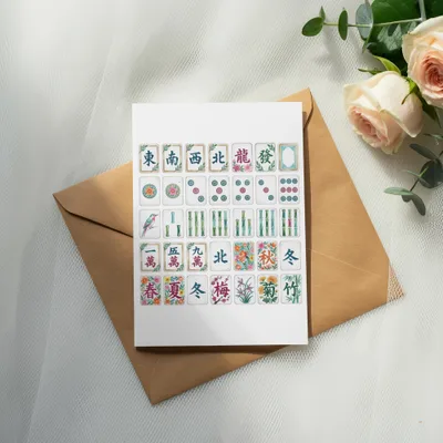 Mahjong tiles and flower motifs on a card placed on a brown envelope.