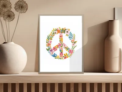 Peace sign art print with floral accents, framed on a shelf.