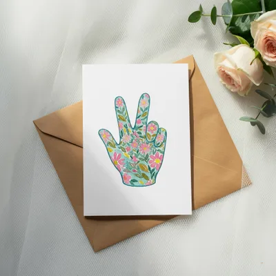 Card with floral peace sign illustration on a kraft envelope.