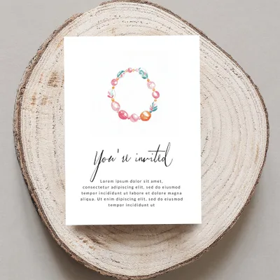 Invitation with floral wreath design and placeholder text.