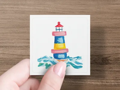 Colorful lighthouse with waves on card held by hand.